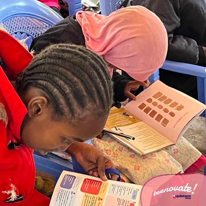 A girl leaning in to read an illustrated health booklet