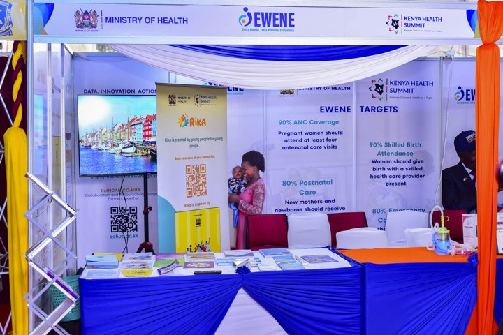 An exhibition stand with EWENE targets banners and a display screen