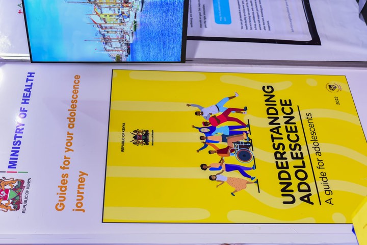 Close-up of the Understanding Adolescence guide cover on a Ministry of Health stand
