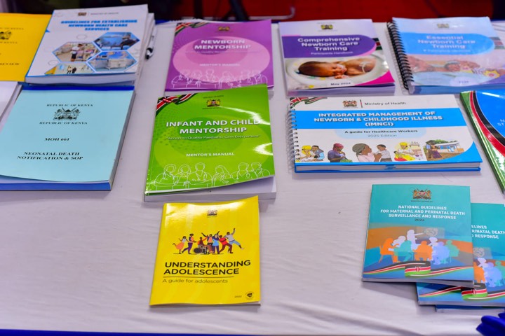 Health publications on a table, including newborn and infant mentorship guides